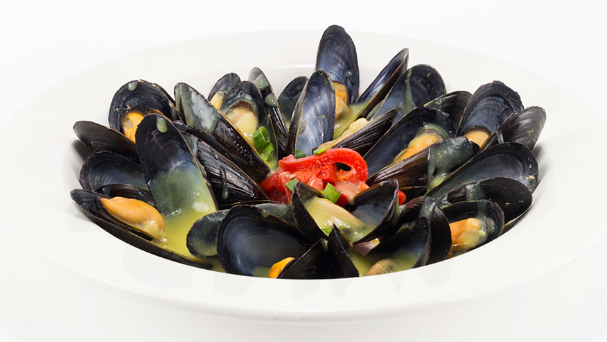 A bowl of mussels in a saffron cream broth.