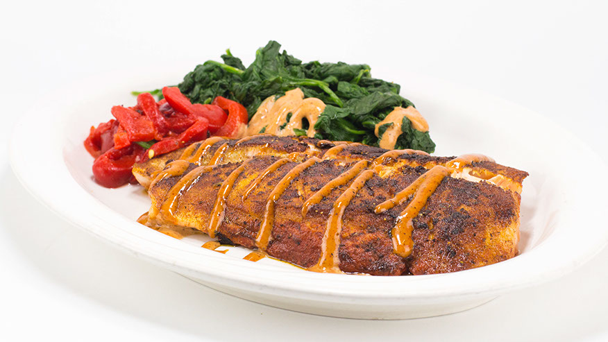 Blackened fish fillet with sauteed spinach and roasted red peppers.