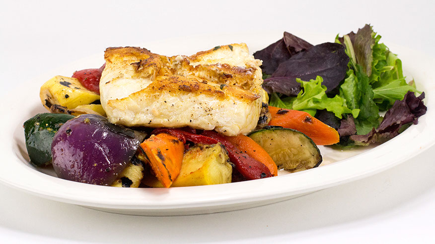Grilled fish over grilled vegetables with mixed greens.